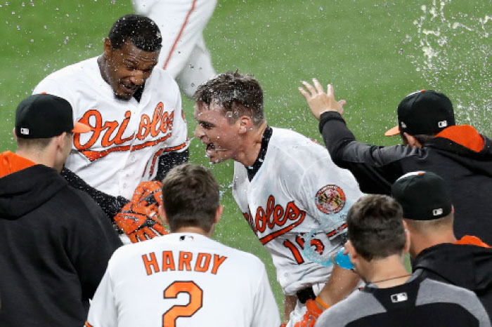 Trey Mancini (R) of the Baltimore Orioles celebrates with teammates at home plate after hitting a walk off three-run homer to defeat the Pittsburgh Pirates at Oriole Park at Camden Yards in Baltimore Wednesday. — AFP