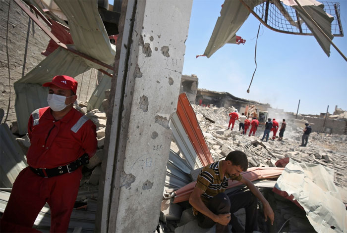 Iraqi civil defense search and rescue workers search for the bodies of victims under the rubble of buildings in western Mosul's Zanjili district this week. With snipers lurking on rooftops and bombs hidden in the rubble, rescue workers are risking their lives in a desperate search for civilians buried during the battle for Mosul. — AFP