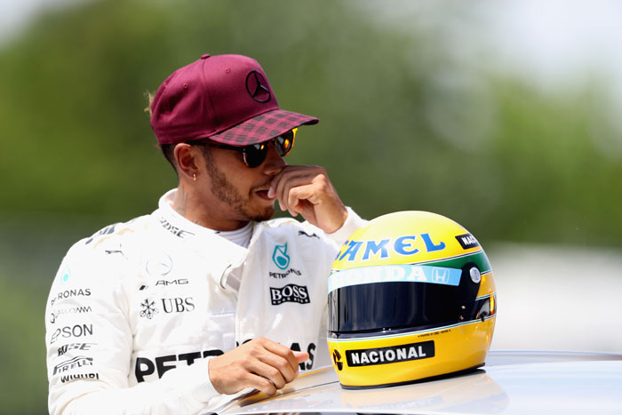 Pole sitter Lewis Hamilton of Great Britain and Mercedes GP poses with a commemorative helmet of F1 legend Ayrton Senna after he beat the previous record of 65 pole positions during qualifying for the Canadian Formula One Grand Prix at Circuit Gilles Villeneuve in Montreal Saturday. — AFP