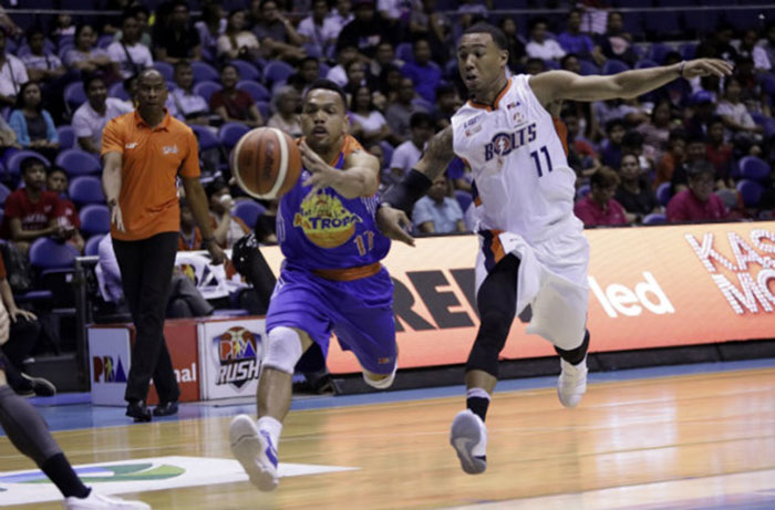 TNT's Jayson Casto is pursued by Meralco's Chris Newsome in their PBA Commissioner's Cup knockout playoff match at the Smart-Araneta Coliseum Friday night.