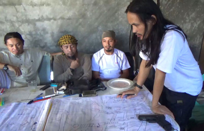 This screengrab taken from handout video released by the Philippine Army on June 18, 2017 shows Abdullah Maute (R) looking at an improvised map of Marawi, while Isnilon Hapilon (2nd L), leader of hardline group Abu Sayyaf looks on, as they plan an attack on Marawi at an undisclosed location on Mindanao island. — AFP