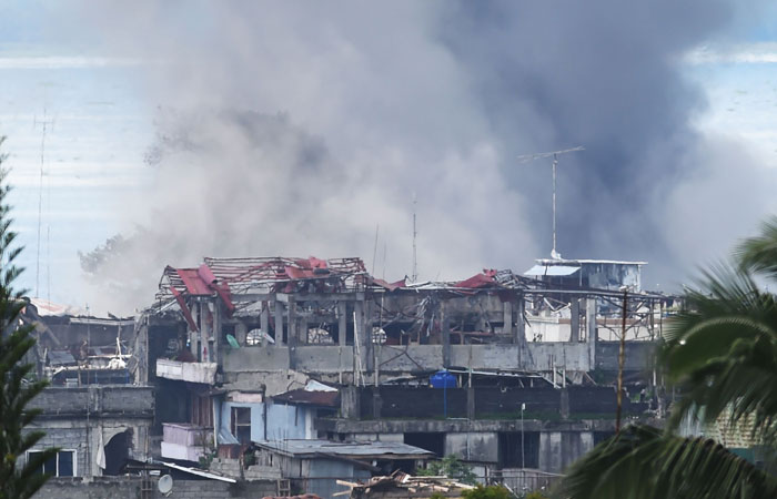 Black smoke billows from burning houses after an aerial bombing by the Philippine Air Force on militant positions in Marawi on the southern island of Mindanao on Tuesday. — AFP