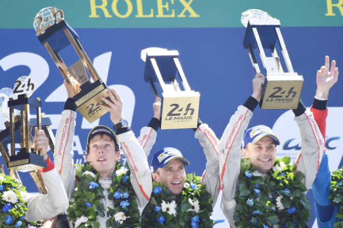 Porsche 919 Hybrid No. 2 team members (from L) German driver Timo Bernhard, New Zeland’s Earl Bamber and New Zeland’s Brendon Hartley celebrate on the podium after the Le Mans 24 Hours Endurance Race in Le Mans Sunday. — AFP