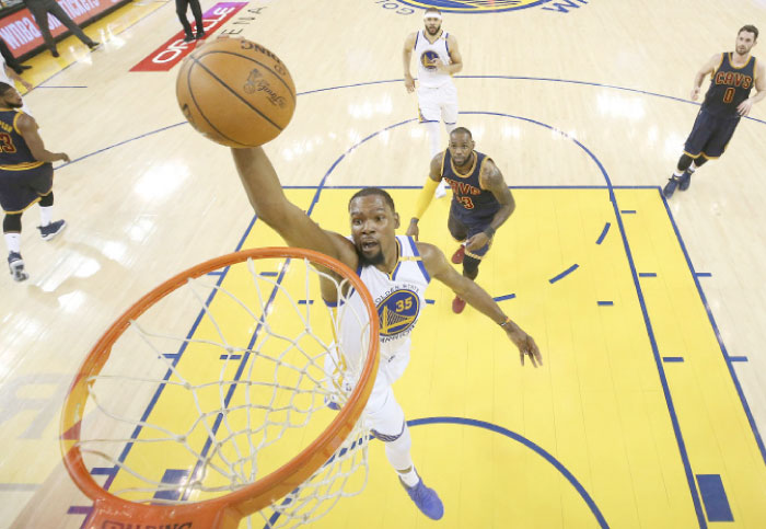 Golden State Warriors’ forward Kevin Durant dunks in front of Cleveland Cavaliers’ forward LeBron James during Game 1 of NBA Finals in Oakland Thursday. — AP