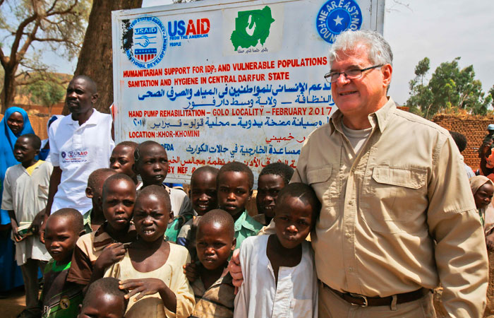 This file photo shows Steven Koutsis (R), the United States' top envoy in Sudan, posing for a picture with Sudanese children and villagers in the war-torn town of Golo in the thickly forested mountainous area of Jebel Marra in central Darfur. Sudan has made 