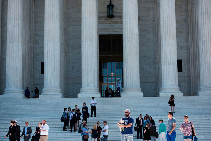 People walk outside the US Supreme Court during their last public session before the summer break Monday in Washington, DC. The US Supreme Court on Monday agreed to hear the case on President Donald Trump's controversial travel ban targeting citizens from six predominantly Muslim countries.  — AFP