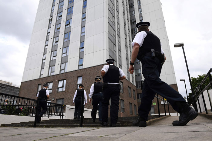 Police officers arrive at Dorney Tower residential block on the Chalcots Estate in north London on Saturday. — AFP