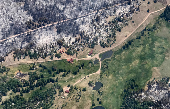 This Monday photo taken by Justin Harding, shows spared cabins near burnout areas around Panguitch Lake, during a wildfire tour by Utah Lt. Gov. Spencer Cox, in southern Utah. — AP