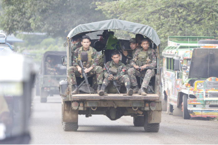 Soldiers ride a military vehicle on the outskirts of Marawi city, southern Philippines, on Friday. — AP