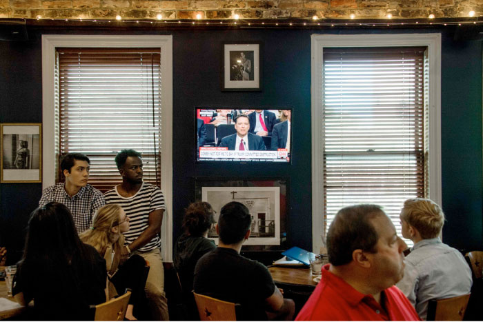 Spectators and patrons at Shaw’s Tavern in northwest Washington, DC, watch as former FBI director James Comey testifies before the Senate Intelligence Committee on Thursday. — AFP