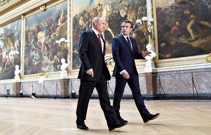 Emmanuel Macron with Vladimir Putin in the Gallery of Battles at the Versailles Palace, near Paris, this week. — AFP