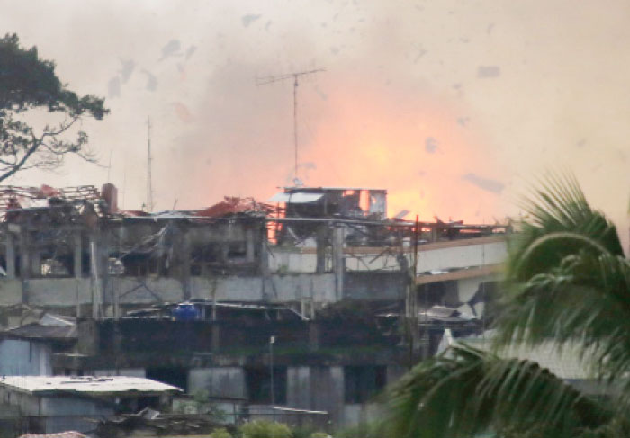 Debris and fire is seen after an OV-10 Bronco aircraft released a bomb, during an air strike, as government forces continue their assault against insurgents from the Maute group, who have taken over large parts of Marawi City, Philippines, on Monday. — Reuters