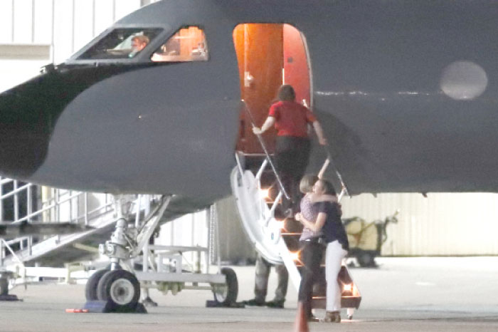 A pair hugs and cries outside the plane carrying Otto Warmbier, a 22-year-old University of Virginia undergraduate student who was imprisoned in North Korea in March 2016, before he is transferred from a transport aircraft to an ambulance at Lunken regional airport, on Tuesday, in Cincinnati. — AP