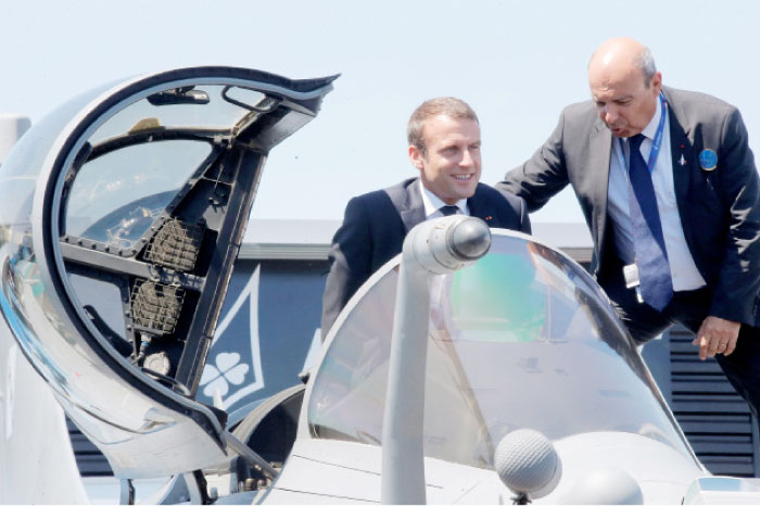 French President Emmanuel Macron exits the cockpit of a Rafale jet fighter helped by Dassault Aviation CEO Eric Trappier, right, during his visit at the 52nd Paris Air Show in Le Bourget, north of Paris, France, on Monday. — Reuters