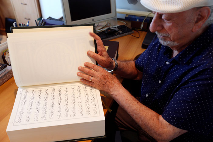 Lebanese calligrapher, Mahmoud Bayoun, turns the pages of the Qur’an that he wrote in Diwani font, at his office in Beirut. — Reuters