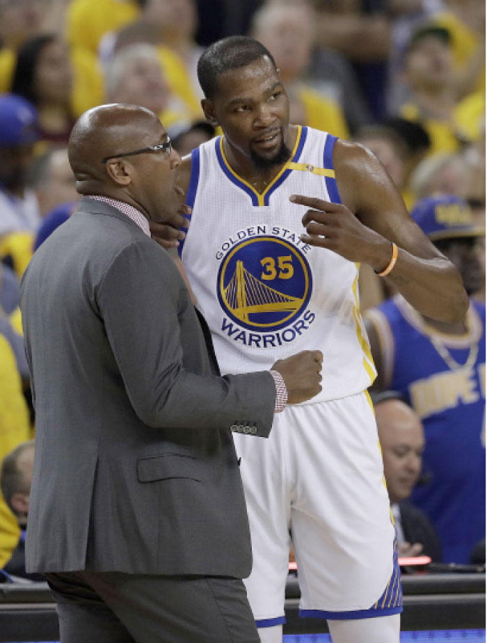 Golden State Warriors forward Kevin Durant (35) talks with interim head coach Mike Brown during the first half of Game 1 of basketball's NBA Finals against the Cleveland Cavaliers, in Oakland, Calif. — AP