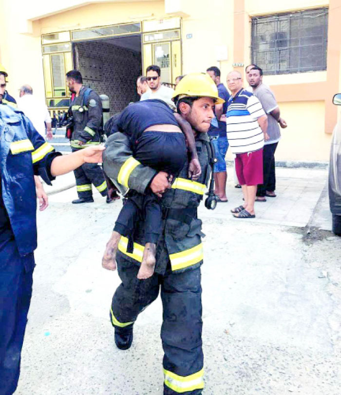 Civil Defense personnel evacuating people from a building which caught fire in Jeddah’s Al-Nuzha District.