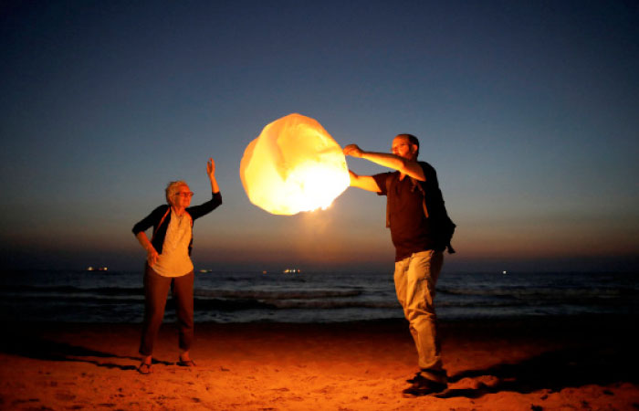 Israeli peace activists release a sky lantern, hoping to illuminate the sky in Gaza, as they protest Israel’s reduction of power supply to Gaza at a beach in Ashkelon, southern Israel. — Reuters