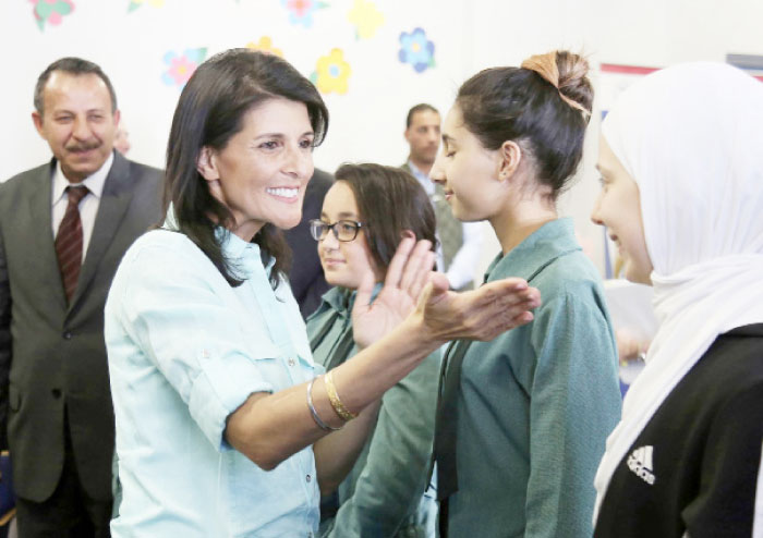 A picture taken on May 21, 2017, shows US Ambassador to the UN Nikki Haley (L) meeting with Syrian refugee students in the Jordanian capital Amman.  — AFP