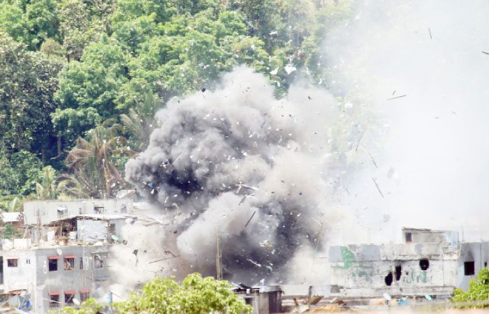 Debris and smoke are seen after an OV-10 Bronco aircraft released a bomb during an airstrike, as government forces continue their assault against insurgents from the Maute group, who have taken over large parts of Marawi City, Philippines, on Tuesday. — Reuters