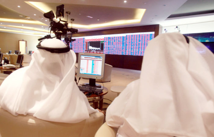 Traders monitor screens displaying stock information at Qatar Stock Exchange in Doha on Monday. The Qatari stock index sank 7.6 percent in the first hour of trade. Some of the market’s top blue chips were hit hardest. — Reuters