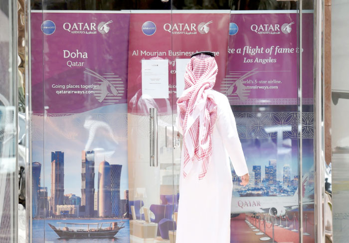 A picture taken on Monday shows a man standing outside the Qatar Airways branch in Riyadh. General Authority of Civil Aviation (GACA) banned all Qatari airlines and aircraft from landing at the Kingdom›s airports. It also banned all private and commercial airlines registered in the Kingdom from operating to Qatar (both direct and non-direct ) with immediate effect. — AFP