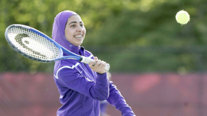 Tabarek Kadhim, a sophomore, wears a sports hijab while playing a tennis match in Windham, Maine.