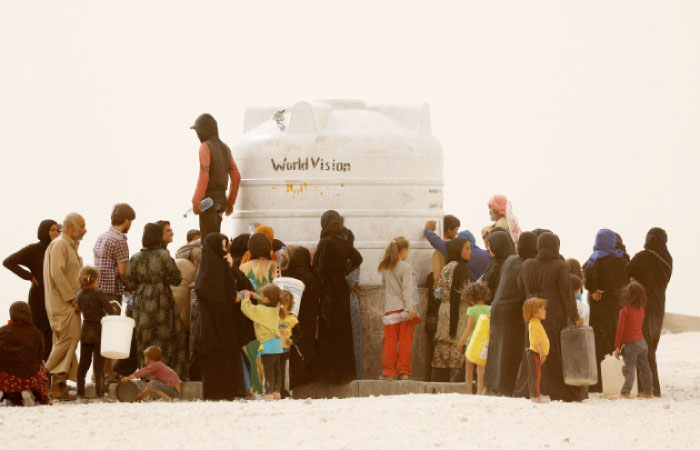 Internally displaced people who fled Raqqa city gather to fill water containers in a camp near Ain Issa, Raqqa governorate, Syria. — Reuters