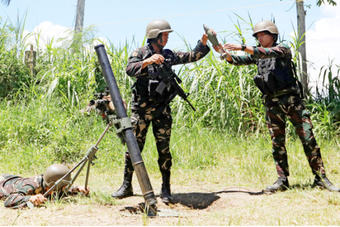 Filipino soldiers prepare to launch a mortar from their combat position as government troops continue their assault against insurgents from the Maute group in Marawi city, Philippines, on Saturday. — Reuters
